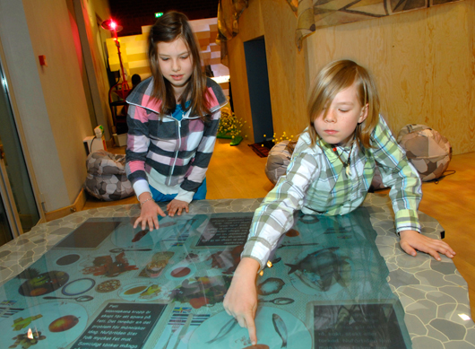 På Historiska museet tar barnen till sig kunskapen om det förflutna via interaktiv teknik. Här använder Norma och Harry en surface board för att lära sig om stenåldersmänniskans matvanor.