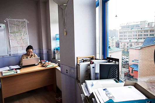 Pearly Jacob, Mongoliet, har valt att dokumentera tolken Mongo vid sitt skrivbord på ett kontor med utsikt över Ulan Bators stadskärna. Kontoret har en västerländsk estetik och mycket lite avslöjar att det faktiskt handlar om Asien.
