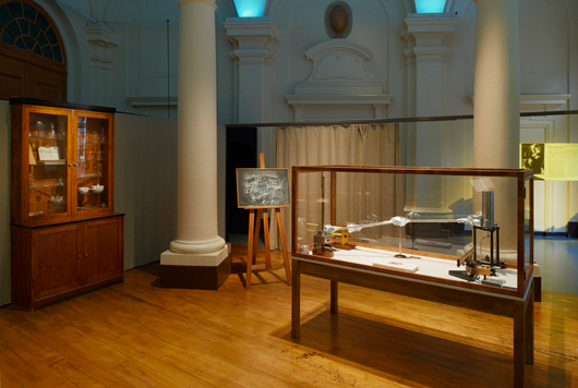 Marie Curie mäter radiumstrålning i sitt laboratorium, instrumentet är rekonstruerat och utställt på Nobelmuseet.