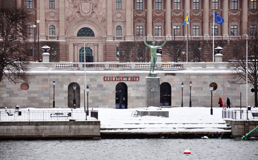 Strömparterren i Stockholm med riksdagshuset i bakgrunden. Framför museet står Carl Milles staty Soldyrkaren och vädjar om en snar snösmältning.
